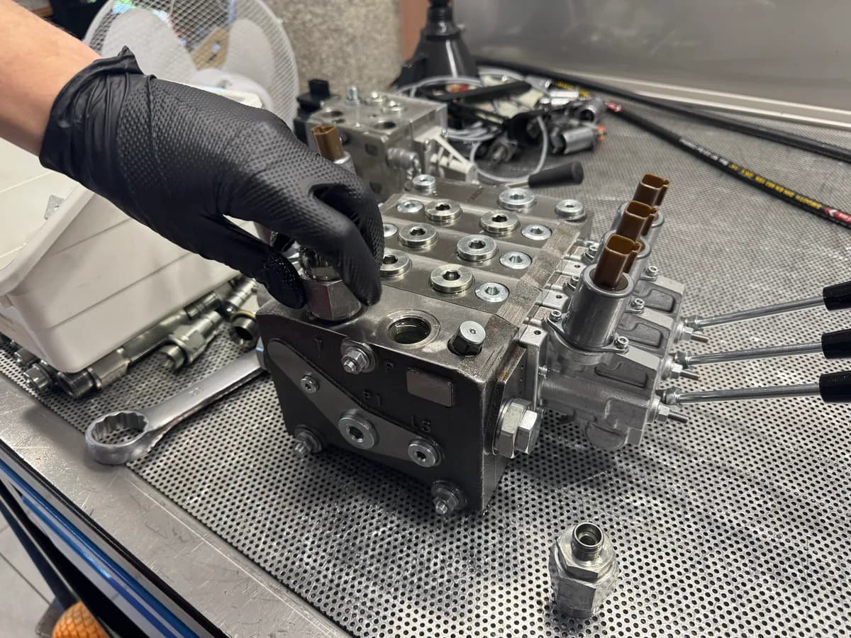 Technician assembling a hydraulic valve block for a custom control kit